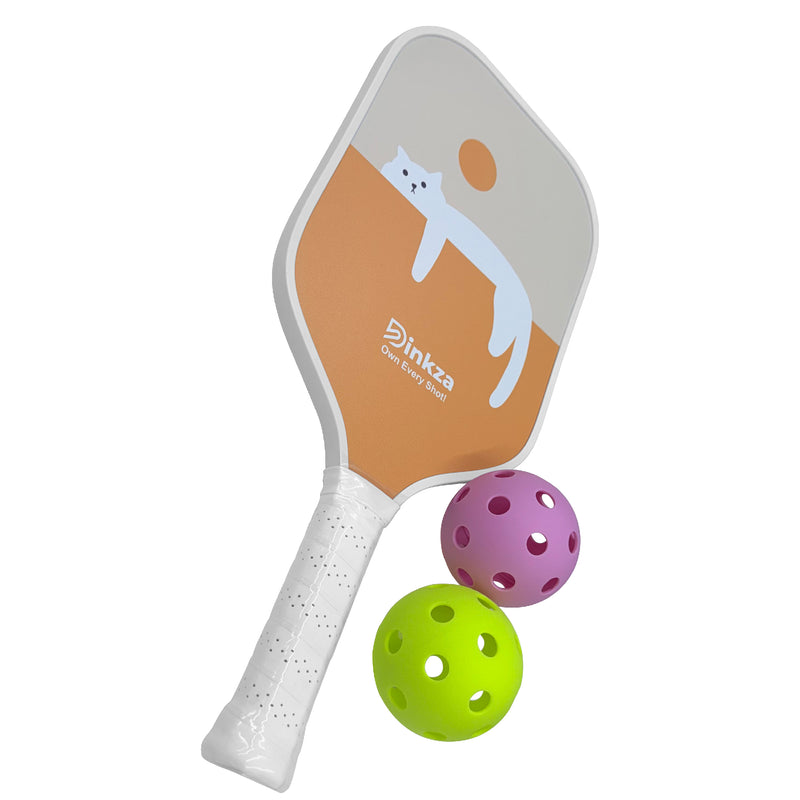 Top view of complete paddle next to pickleball on court.
